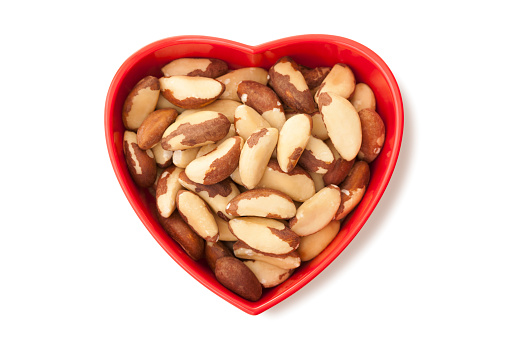 Brazil nuts inside heart shaped bowl. Isolated on a pure white background, absolutely no dot in the white area no need to cut-out e.g. can be dropped directly on to a white web page seemlessly.