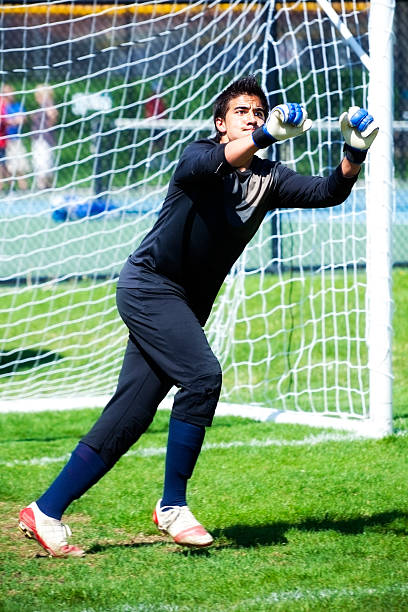 Male Soccer Goaltender Uses Two-Fisted Goal Keeping Technique stock photo