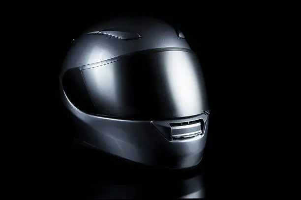 silver motorcycle helmet on black background.