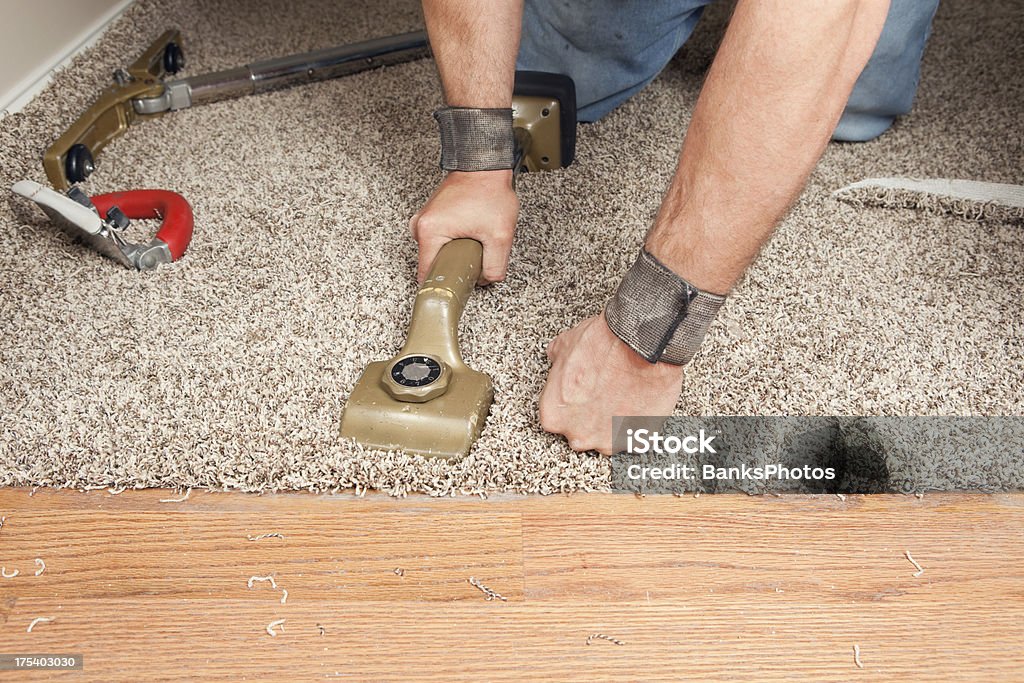 Instalador utilizando la rodilla Kicker para distenderse umbral alfombra - Foto de stock de Madera noble libre de derechos
