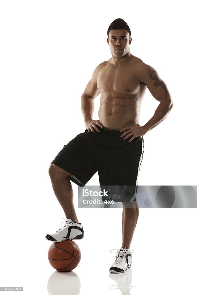 Athlete standing with one foot on a basketball Athlete standing with one foot on a basketballhttp://www.twodozendesign.info/i/1.png Shirtless Stock Photo