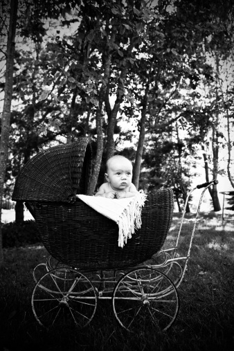 An outdoor portrait of a baby boy in a carriage from the 1920's.