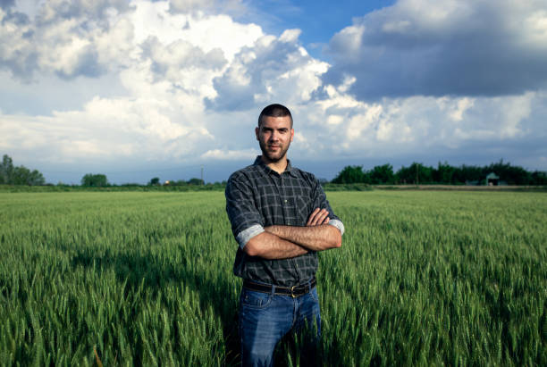 istock Young farmer standing in a green wheat field examining crop. 1754037427