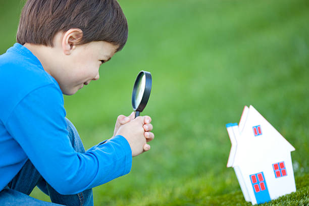 boy with loupe looking  house-miniature "little boy with loupe looking a house-miniature,for future family concepts,very selective focus on the boyA's eye ,house self made" hypothecary stock pictures, royalty-free photos & images