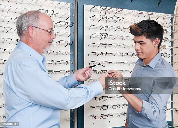 Jovem De Tentar Novos Óculos Em Optometrista - Fotografias de stock e mais imagens de Adulto - Adulto, Duas Pessoas, Fila - Arranjo