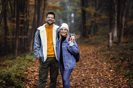 Portrait of couple spending time together walking in forest.