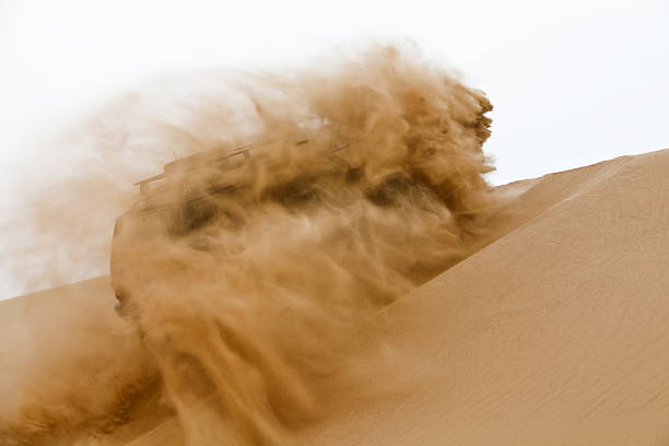 Off-road car going up the sand dune stock photo