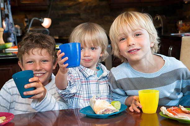 istock Three brothers with milk mustaches at lunch. 175404788