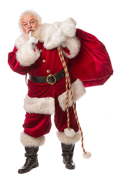 pictures of Real Santa Claus Has A Gift Bag pictures of Real Santa Claus carrying his toy bag with his fingers on his lips motioning to be quiet. This stock image is a vertical composition isolated on white santa claus expressions shhh stock pictures, royalty-free photos & images