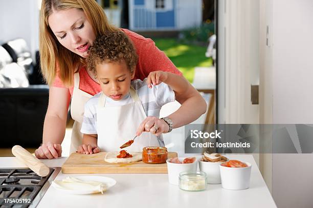 Europäischer Abstammung Mutter Hilft Sohn Machen Tomatenmark Auf Die Pizzateig Stockfoto und mehr Bilder von Kleinstkind