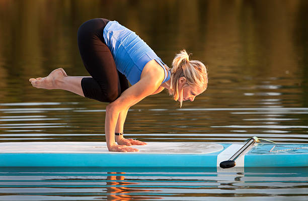 istock Woman doing exquisite yoga pose on paddle board on a lake 175405645