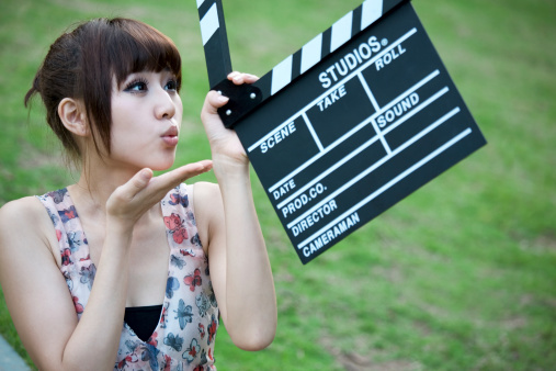 Pretty young woman holding a clapper