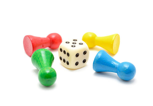 Colored  Board Game Pieces lie around dice on white background