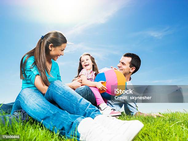 Giovane Famiglia Felice Contro Il Cielo Sereno - Fotografie stock e altre immagini di Famiglia - Famiglia, Giocare, Abbigliamento casual