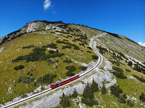 Famous railway from Wengen and Lauterbrunnen valley to Jungfraujoch. Red modern mountain train driving trough Swiss Alps.