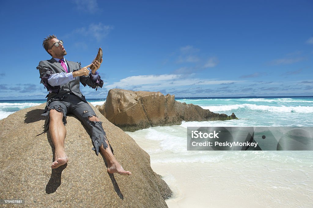 Изгой бизнесмен, используя смартфон на пляже кокосового волокна, крабовые фермы - Стоковые фото Необитаемый остров роялти-фри