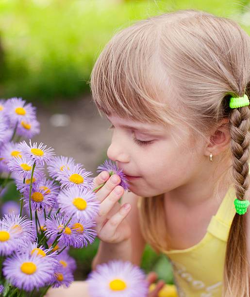 istock girl smelling flower 175408321