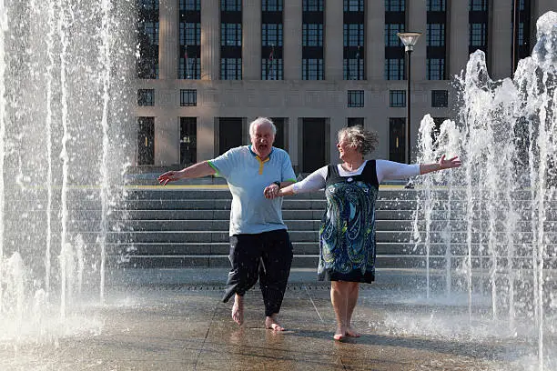 Photo of mature couple dance in fountains