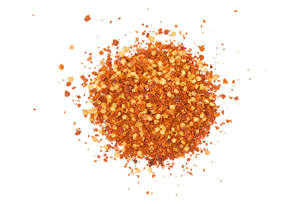 Spicy Pile of red hot chili flakes isolated on a white background. cayenne powder stock pictures, royalty-free photos & images