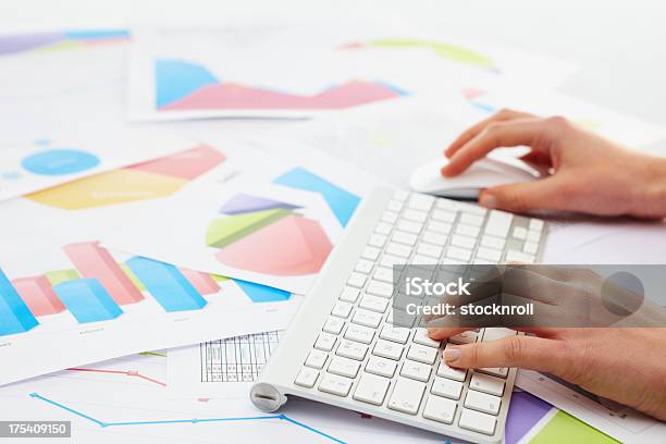 Mujer Escribiendo En Keybord Con Gráficos En Su Foto de stock y más banco de imágenes de Adulto - Adulto, Ahorros, Analizar