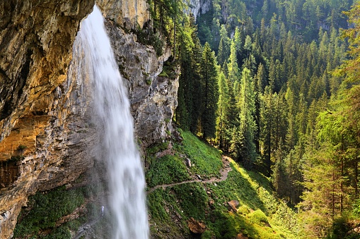 Johannes Waterfall (Johanneswasserfall) in Obertauern. It has tourist trail beneath the waterfall. Natural landmark of Tauern mountains in Austria.