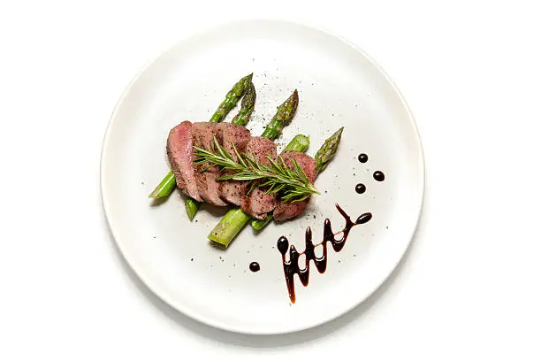 Filet of Lamb sliced on a bed of Asparagus with Balsamic Vinegar decoration