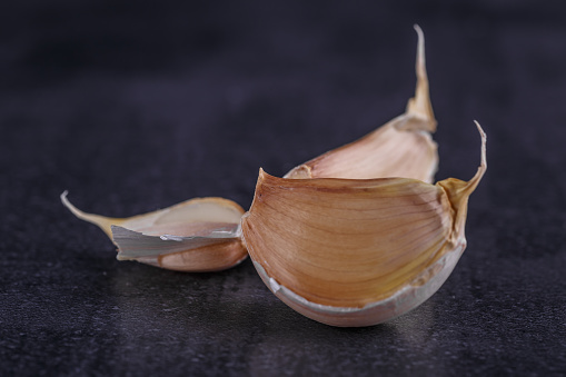 garlic and garlic bulbs on a black plate