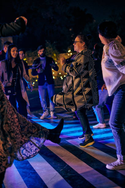 fête nocturne multinationale des gens drôles dansant sur la piste de danse en plein air avec des projecteurs multicolores - indian culture dancing dancer women photos et images de collection