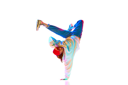 Dynamic image of man in his 30s hip hop dancer in motion isolated over white studio background in neon light. Concept of contemporary dance, street style, fashion, hobby, youth. Ad