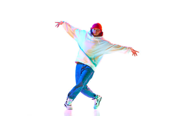 istock Man in his 30s wearing sport style clothes and dancing breakdance isolated over white studio background in neon light 1754099835