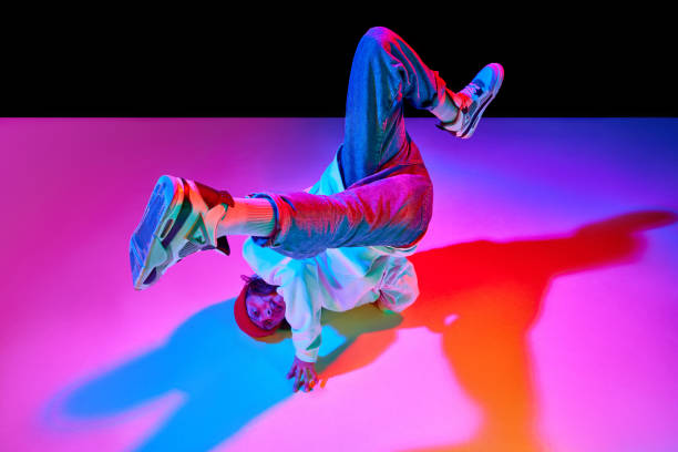 istock Dynamic image of man in his 30s in motion, dancing breakdance isolated over black studio background in neon light 1754099870