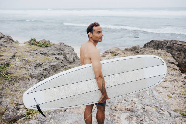 istock A lone surfer walking towards the ocean on a cloudy day 1754103384