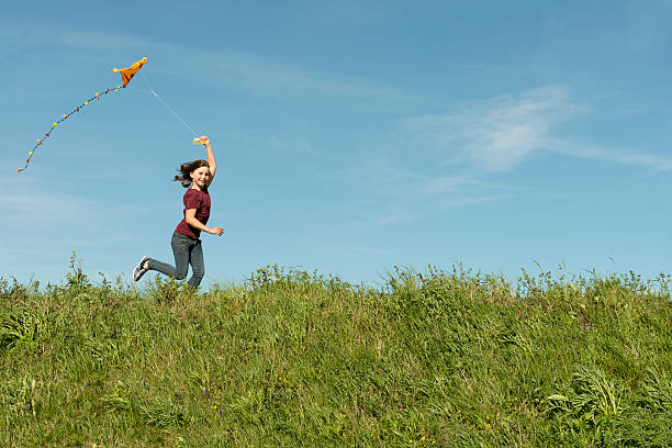 istock happy girl flying her kite 175410479