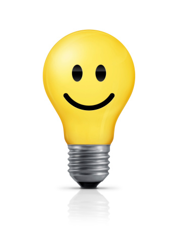 Yellow light bulb with smiley face. Isolated on white background.