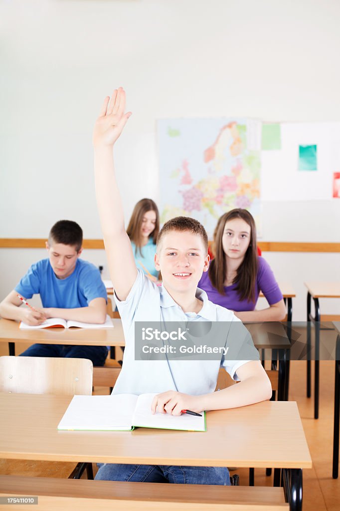 Niño en edad escolar responder a las preguntas de los profesores en montaje tipo aula. - Foto de stock de 10-11 años libre de derechos