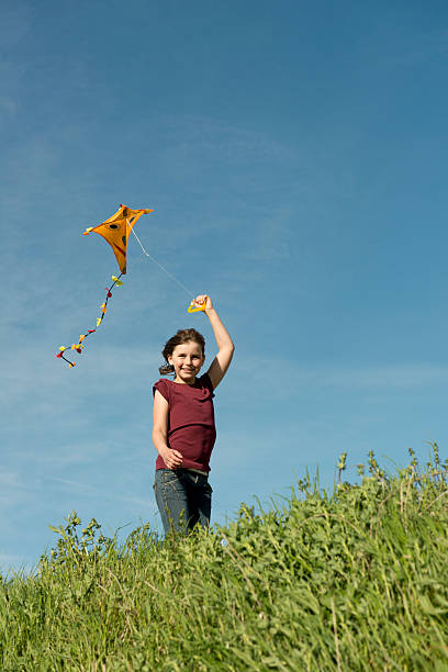 istock happy girl flying her kite 175411152