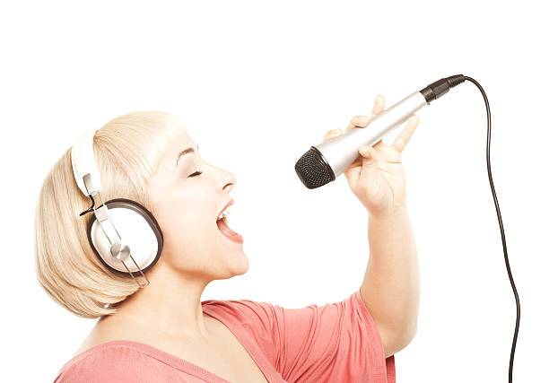 Close up of a woman using a microphone, isolated on a white background.