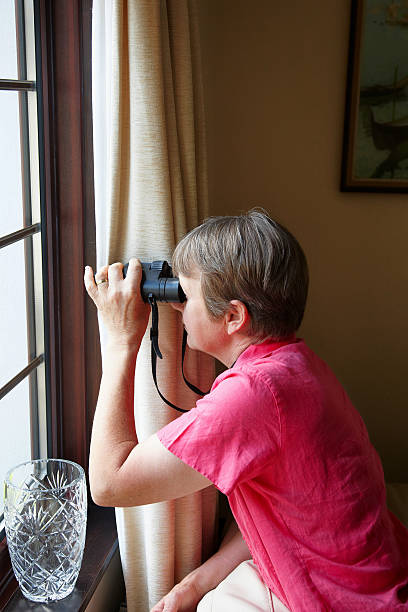 istock Nosey neighbour at the window with binoculars 175412084