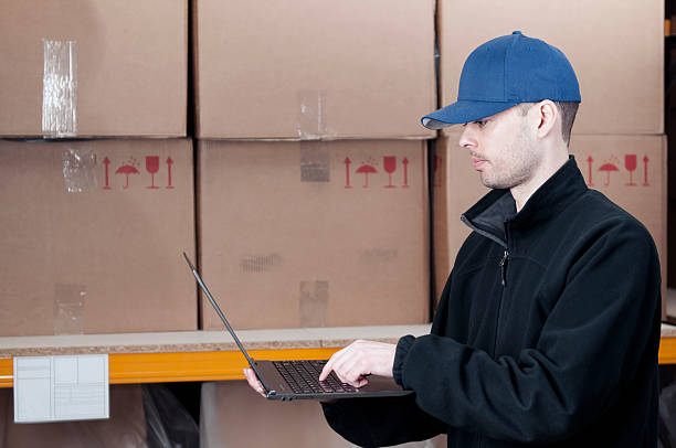 istock Worker in storage room with laptop 175412107