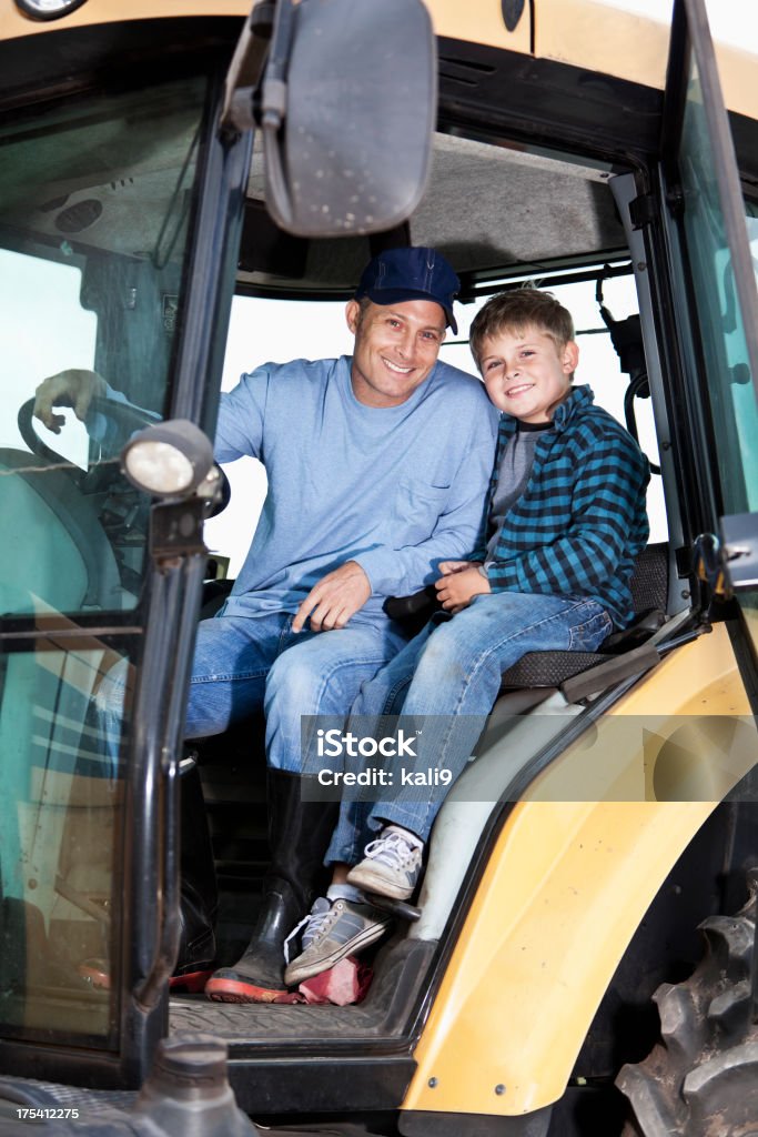 Chłopiec i ojciec na ciągniku - Zbiór zdjęć royalty-free (Traktor)