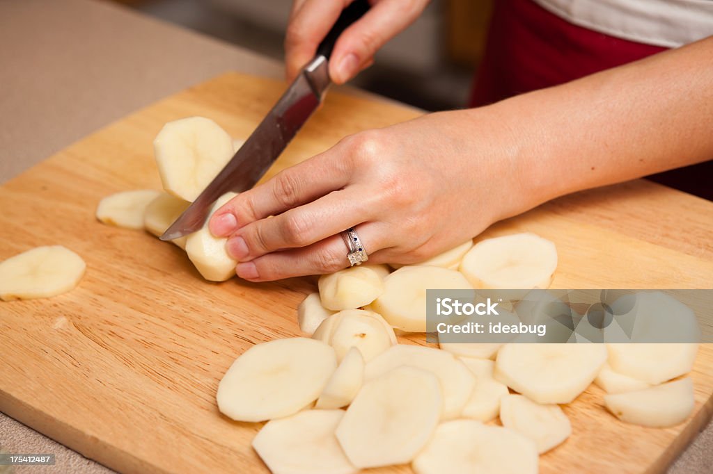 Plano aproximado de mulher cortar batatas em sua cozinha - Royalty-free Batata Crua Foto de stock