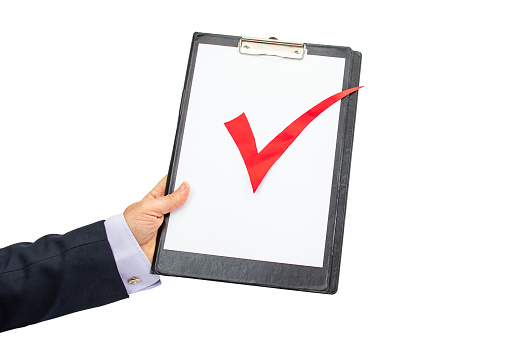 Business man hand holding a clipboard with a red check sign , isolated on white background