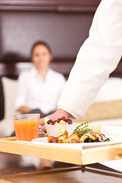 Room service setting down a nice breakfast for hotel guest Room service setting down a nice breakfast for hotel guest. room service stock pictures, royalty-free photos & images