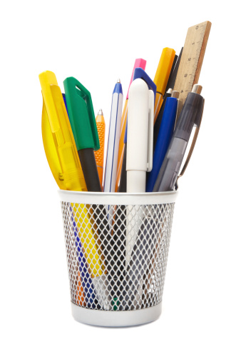 Various writing instruments in a wire mug. Isolated on a white background.