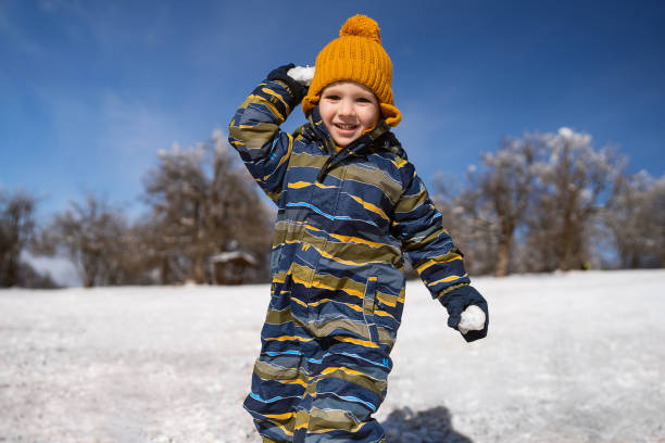 Little boy throwing snowball