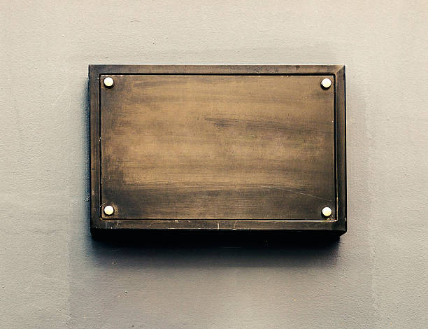 Blank metal plaque Blank metal plate on gray wall. bronze colored photos stock pictures, royalty-free photos & images