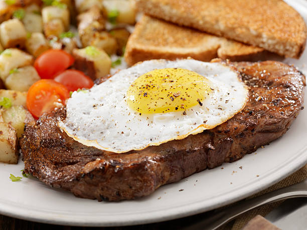 Steak and Eggs "Grilled Rib Eye Steak with Sunny-side up Eggs, Hash Browns, Grilled Tomatoes and Toast -Photographed on Hasselblad H3D2-39mb Camera" steak and eggs breakfast stock pictures, royalty-free photos & images