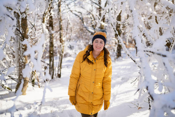 Woman enjoying a walk through a snowy forest.
