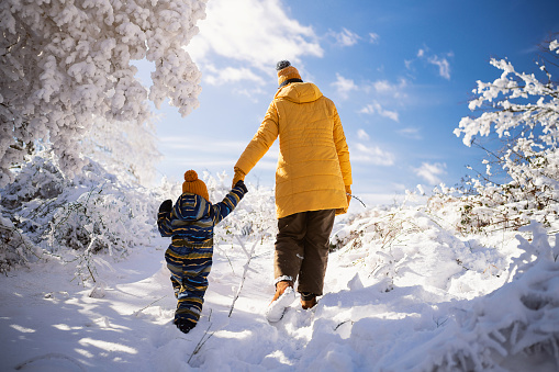 Mom and son enjoying a carefree winter day on the snowy mountain.