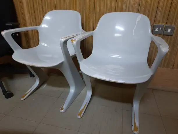 Egypt, Kafr El-Sheikh, 10-11-2023, two old plastic chairs with a futuristic style in front of a 1970s-style wall.